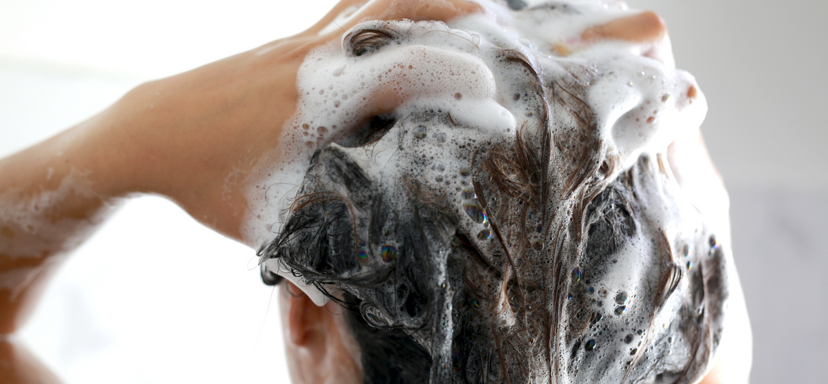 Visuel d'une personne faisant un shampoing usage fréquent bio Cattier qui mousse